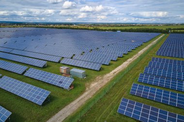 Temiz elektrik enerjisi üretmek için sıra sıra güneş fotovoltaik panelleri olan sürdürülebilir büyük elektrik santralinin havadan görünüşü. Sıfır emisyonlu yenilenebilir elektrik kavramı