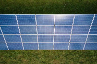 Temiz elektrik enerjisi üretmek için birçok sıra güneş fotovoltaik paneli bulunan sürdürülebilir büyük elektrik santralinin havadan görünüşü. Sıfır emisyon kavramı ile yenilenebilir elektrik