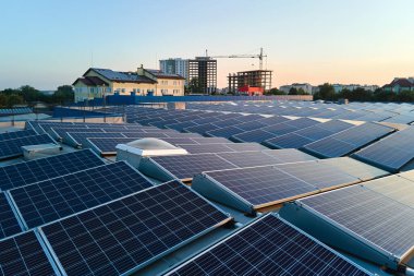 Sanayi binasının çatısına yeşil ekolojik elektrik üretmek için monte edilmiş mavi fotovoltaik panelli güneş enerjisi santralinin hava görüntüsü. Sürdürülebilir enerji konsepti üretimi