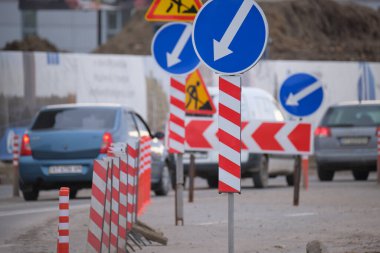 Yol çalışmaları trafik işaretlerini uyardı. Şehir caddesinde inşaat çalışması ve yavaş hareket eden arabalar.