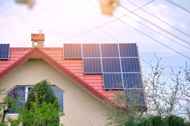 Şehrin kırsal kesimlerinde temiz ekolojik elektrik enerjisi üretmek için güneş fotovoltaik panellerle kaplı özel bir çatı. Özerk ev kavramı