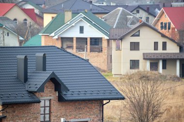 Evin çatısındaki baca inşaat halindeki metalik kiremitlerle kaplı. Binayı kaplayan fayanslar. Gayrimenkul geliştirme