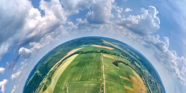 Dünya gezegeninin yüksek irtifasından yeşil ve sarı ekili tarım tarlaları ile aydınlık yaz gününde ekinlerin büyümesi.