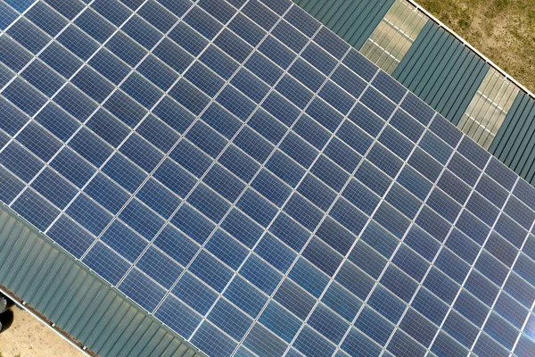 Luchtfoto van blauwe fotovoltaïsche zonnepanelen gemonteerd op industrieel gebouwendak voor de productie van groene ecologische elektriciteit. Productie van concept voor duurzame energie — Stockfoto