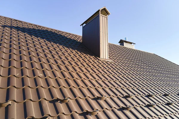 Closeup snow guard for safety in winter on house roof top covered with steel shingles. Tiled covering of building — Stock Photo, Image