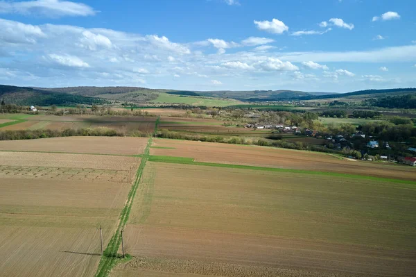 Vista aérea de campos agrícolas arados com solo fértil cultivado preparado para plantar culturas entre florestas verdes na primavera — Fotografia de Stock