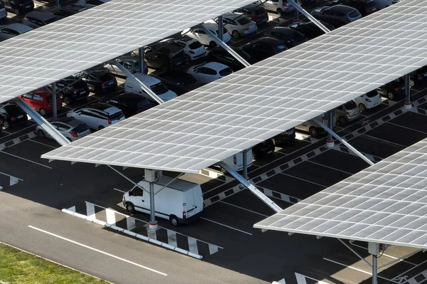 Güneş panellerinin hava görüntüsü park yerinin üzerine gölge çatısı olarak yerleştirilmiş ve temiz elektriğin etkin üretimi için park edilmiş arabalar var. Fotovoltaik teknoloji şehir altyapısına entegre edildi