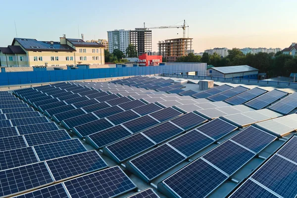 緑の生態系電気を生成するための産業用建物の屋根の上にマウントされている青い太陽光発電パネルの空中ビュー。持続可能なエネルギー概念の生産 — ストック写真