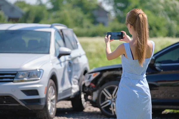 Грустная женщина-водитель, фотографирующая на камеру продавца, разбила машины на улице для страховой службы после автомобильной аварии. Концепция дорожной безопасности — стоковое фото