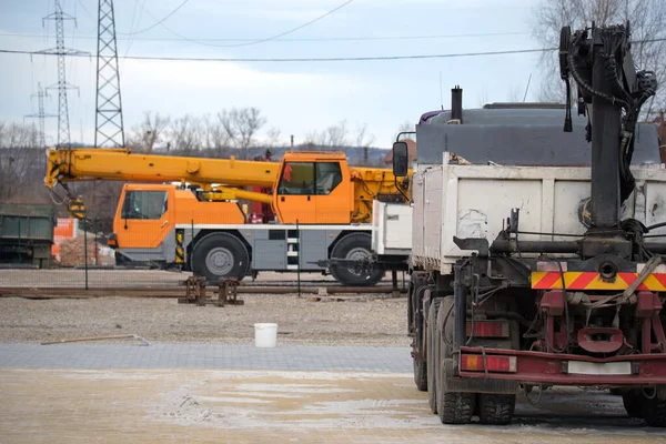Caminhão pesado e guindaste de elevação móvel no local de construção — Fotografia de Stock