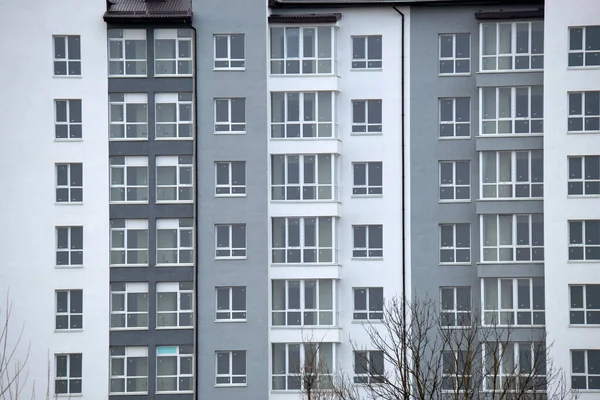 Detalles arquitectónicos de la moderna fachada del edificio de apartamentos altos con muchas ventanas y balcones — Foto de Stock