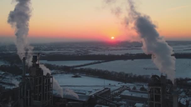 Widok z lotu ptaka cementowni o wysokiej konstrukcji betonowej i żurawia wieżowego na przemysłowym obszarze produkcyjnym wieczorem. Koncepcja przemysłu wytwórczego i globalnego — Wideo stockowe