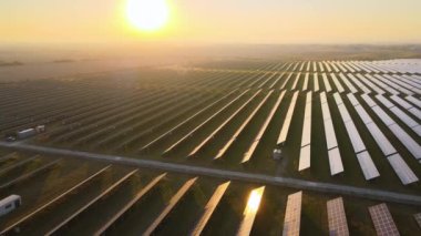 Akşamları temiz elektrik enerjisi üretmek için sıra sıra güneş fotovoltaik panelleri olan sürdürülebilir büyük elektrik santralinin havadan görünüşü. Sıfır emisyonlu yenilenebilir elektrik kavramı