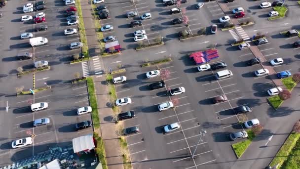 Widok z lotu ptaka na wiele kolorowych samochodów zaparkowanych na parkingu z liniami i oznaczeniami miejsc parkingowych i kierunków — Wideo stockowe