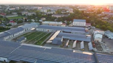 Sanayi binasının çatısına yeşil ekolojik elektrik üretmek için monte edilmiş mavi fotovoltaik panelli güneş enerjisi santralinin hava görüntüsü. Sürdürülebilir enerji konsepti üretimi