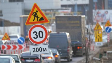 Yol çalışmaları trafik işaretlerini uyardı. Şehir caddesinde inşaat çalışması ve yavaş hareket eden arabalar.