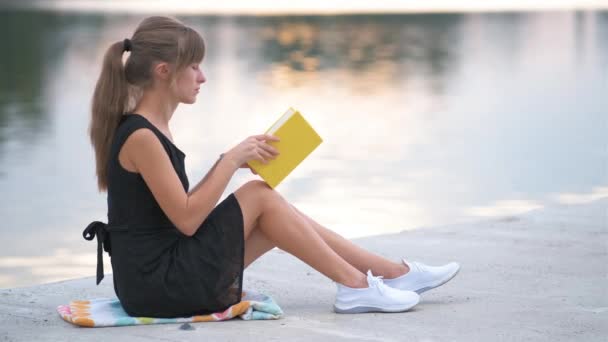 Jovem descansando no parque de verão lendo um livro. Educação e conceito sudy — Vídeo de Stock