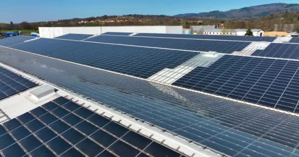 Vista aérea de painéis solares fotovoltaicos azuis montados no telhado de construção industrial para a produção de eletricidade ecológica verde. Produção de conceito de energia sustentável — Vídeo de Stock