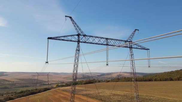 Høyspenttårn med elektriske kraftledninger som overfører elektrisk energi gjennom kabelledninger – stockvideo