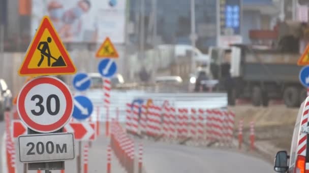 도로 관리인들은 도시의 거리에서 건축 공사를 하고 천천히 움직 이는 차들에 대해 경고하는 교통 표지 — 비디오