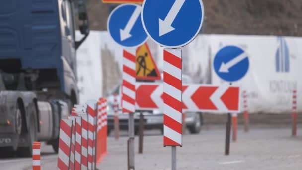 Vägarbeten varnar trafikskyltar för byggnadsarbeten på stadsgatan och långsamgående bilar — Stockvideo