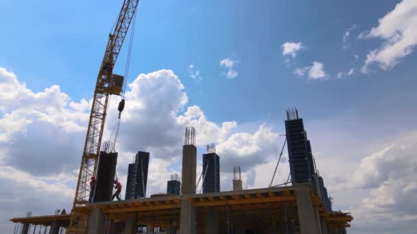 Věžové jeřáby a profesionální pracovníci na vysoké betonové obytné budově ve výstavbě. Koncept developmentu nemovitostí — Stock video