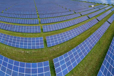 Temiz elektrik enerjisi üretmek için birçok sıra güneş fotovoltaik paneli bulunan sürdürülebilir büyük elektrik santralinin havadan görünüşü. Sıfır emisyon kavramı ile yenilenebilir elektrik