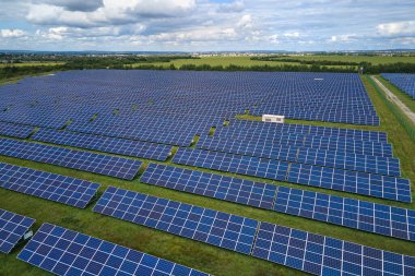 Temiz elektrik enerjisi üretmek için birçok sıra güneş fotovoltaik paneli bulunan sürdürülebilir büyük elektrik santralinin havadan görünüşü. Sıfır emisyon kavramı ile yenilenebilir elektrik