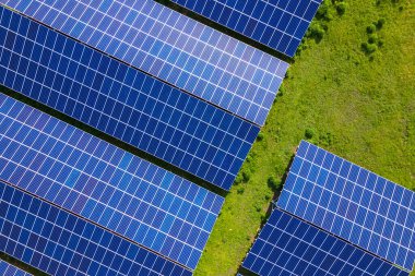 Temiz ekolojik elektrik enerjisi üretmek için sıra sıra güneş fotovoltaik panelleri olan sürdürülebilir büyük elektrik santralinin havadan görünüşü. Sıfır emisyon kavramı ile yenilenebilir elektrik
