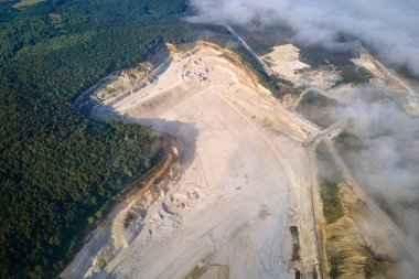 Kazı araçları ve çöp kamyonları ile inşaat endüstrisi için kireçtaşı malzemelerinin açık çukur madenciliğinin hava görüntüsü