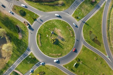 Aerial view of road roundabout intersection with moving heavy traffic. Urban circular transportation crossroads