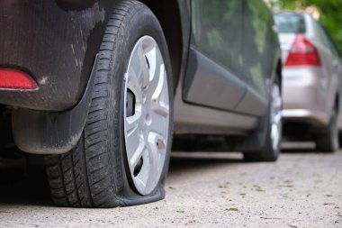 Yol kenarında lastiği patlamış bir araba.