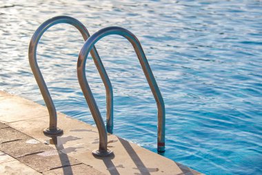 Yüzme havuzuna yakın paslanmaz çelik korkuluklar kaplumbağaların temiz havuz suyuna iniyor. Eğlence etkinlikleri kavramının erişilebilirliği