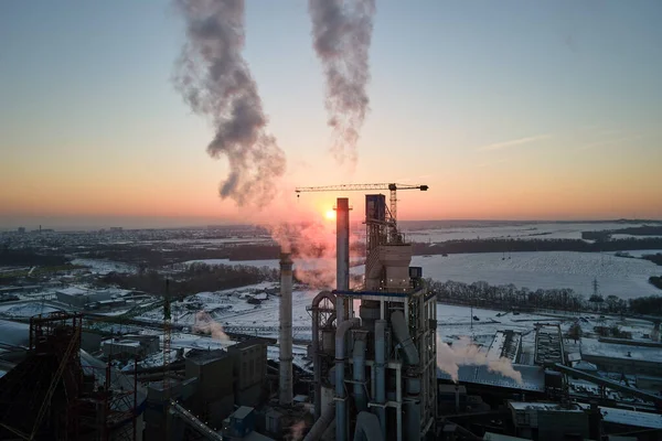 Vue aérienne de la cimenterie avec structure en béton élevé et grue à tour dans la zone de production industrielle en soirée. Fabrication et concept d'industrie mondiale — Photo