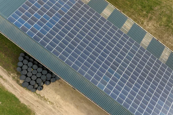 Вид с воздуха на фермерское здание с фотоэлектрическими солнечными панелями, установленными на крыше для производства экологически чистой электроэнергии. Производство концепции возобновляемых источников энергии — стоковое фото