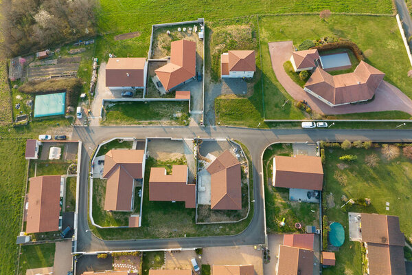 Aerial view of residential houses in green suburban rural area.