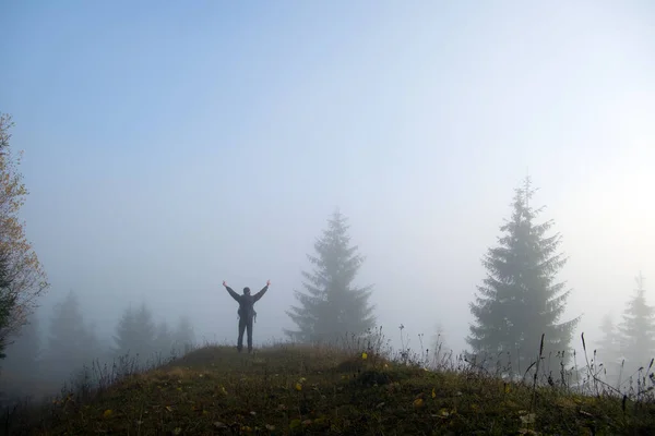 Small figure of lonely hiker enjoying his time on wild forest trail on foggy autumn day — Stock Fotó