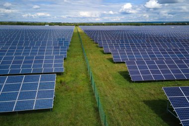 Temiz elektrik enerjisi üretmek için birçok sıra güneş fotovoltaik paneli bulunan sürdürülebilir büyük elektrik santralinin havadan görünüşü. Sıfır emisyon kavramı ile yenilenebilir elektrik