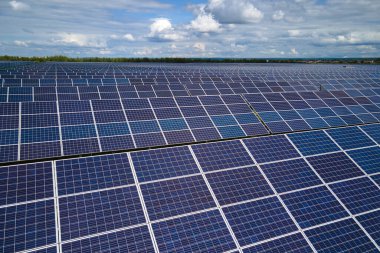 Temiz elektrik enerjisi üretmek için birçok sıra güneş fotovoltaik paneli bulunan sürdürülebilir büyük elektrik santralinin havadan görünüşü. Sıfır emisyon kavramı ile yenilenebilir elektrik