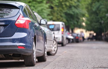Sokak kenarında park halindeki arabalarla şehir trafiği