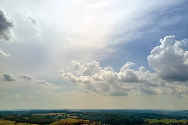 Αεροφωτογραφία τοπίου του καθαρού γαλάζιου ουρανού πάνω από πράσινα καλλιεργούμενα αγροκτήματα με καλλιέργειες και μακρινά δάση σε φωτεινή καλοκαιρινή μέρα — Φωτογραφία Αρχείου