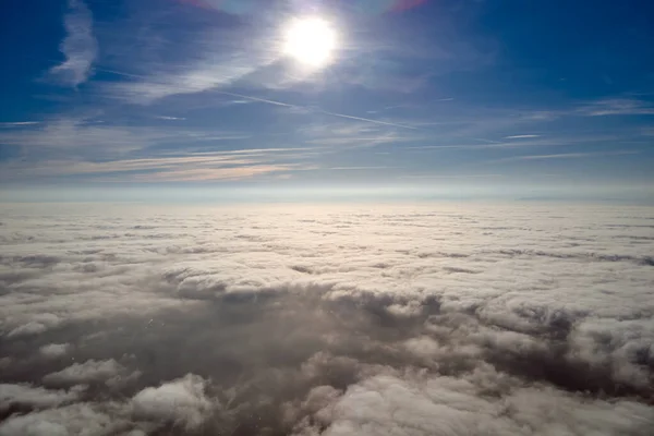 Aerial view from high altitude of earth covered with white puffy cumulus clouds on sunny day — Stock Photo, Image