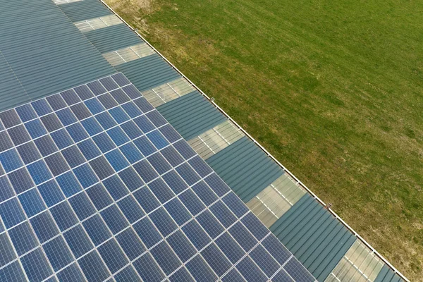 Воздушный обзор солнечной электростанции с голубыми фотоэлектрическими панелями, установленными на крыше промышленного здания для производства зеленой экологической электроэнергии. Производство концепции устойчивой энергетики — стоковое фото