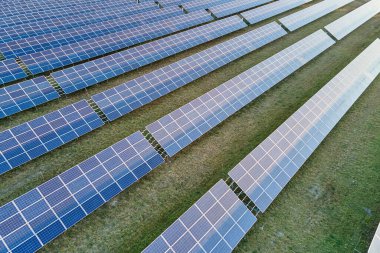 Temiz ekolojik elektrik enerjisi üretmek için sıra sıra güneş fotovoltaik panelleri olan sürdürülebilir büyük elektrik santralinin havadan görünüşü. Sıfır emisyon kavramı ile yenilenebilir elektrik
