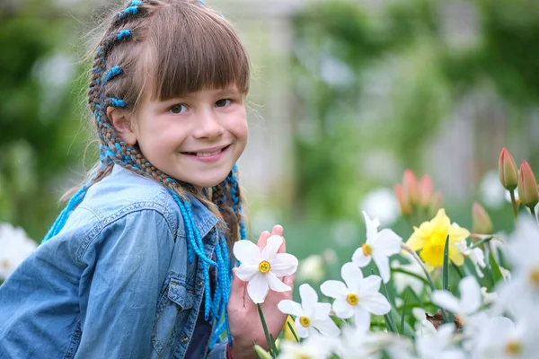 Glad barn flicka leker i sommarträdgården njuter söt doft av vita narcissus blommor på solig dag — Stockfoto