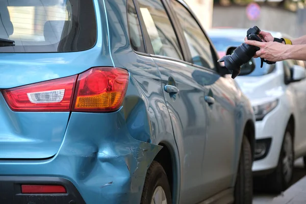 Trabajador de seguros tomando fotos en la cámara del guardabarros abollado en el lado de la calle para el servicio de emergencia después de un accidente de coche. Concepto de seguridad vial y seguros — Foto de Stock