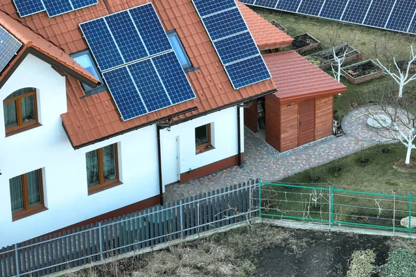 Şehrin kırsal kesimlerinde temiz ekolojik elektrik enerjisi üretmek için güneş fotovoltaik panellerle kaplı özel bir çatı. Özerk ev kavramı — Stok fotoğraf