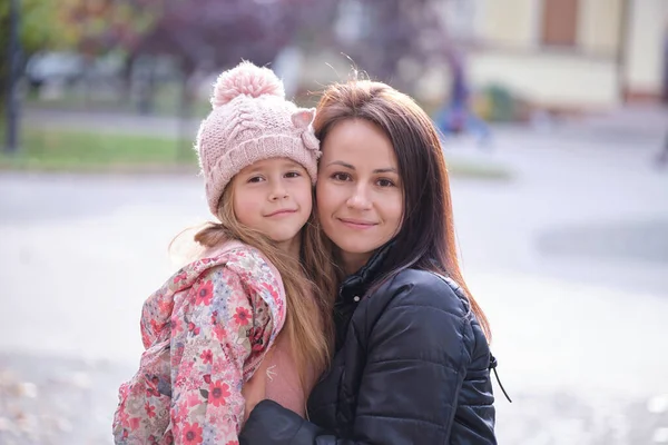 Jovem mulher bonita abraçando amorosamente sua filha criança. Felicidade no conceito de relações familiares — Fotografia de Stock