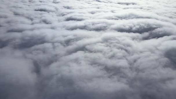 Aerial view from airplane window at high altitude of earth covered with puffy cumulus clouds forming before rainstorm — Stock Video