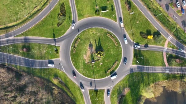 Aerial view of road roundabout intersection with fast moving heavy traffic. Urban circular transportation crossroads — ストック動画
